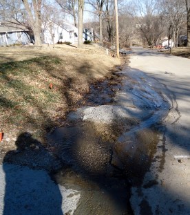 A look at the water down the street,  freezing wide before eroding deep.