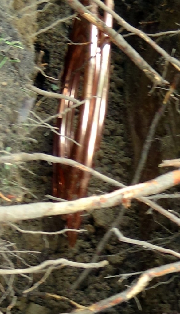 Roll of copper pipe in the trench.